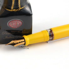 Load image into Gallery viewer, Close up to the grip section, nib, and ink bottle on a white background. 
