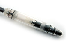 Load image into Gallery viewer, Close up to the barrel section of the pen on a white background. The inside of the pen&#39;s piston is visible. 
