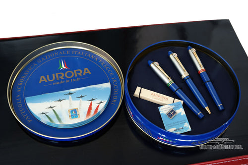 View of the Fountain Pens on the round tin packaging with the contents included. Set on a white and black background. 
