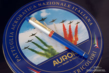 Load image into Gallery viewer, Front view of the blue and red rollerball pen on top of the presentation tin lid.
