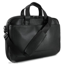 Load image into Gallery viewer, Angled front view of the black briefcase with the shoulder strap draped across it. 
