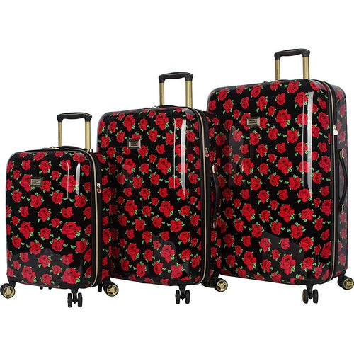Angled view of the three hard-sided suitcases on a white background. All three feature a design of a black background filled with a pattern of red roses.