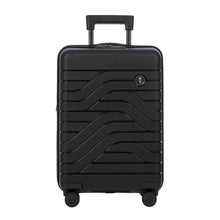 Load image into Gallery viewer, Front view of the black hard shell suitcase. The panel has a textured wave lines design, and a small black circular logo at the top right. The telescopic handle is partly pulled up.
