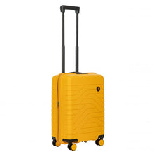 Load image into Gallery viewer, Angled front view of the mango yellow hard shell suitcase with black accents. The front panel has a textured wave lines design, and a small black circular logo at the top right. The telescopic handle is pulled up.

