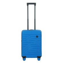 Load image into Gallery viewer, Front view of the electric blue hard shell suitcase with black accents. The panel has a textured wave lines design, and a small black circular logo at the top right. The telescopic handle is pulled up.

