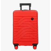 Load image into Gallery viewer, Front view of the red hard shell suitcase with black accents. The panel has a textured wave lines design, and a small black circular logo at the top right. The telescopic handle is partly pulled up.
