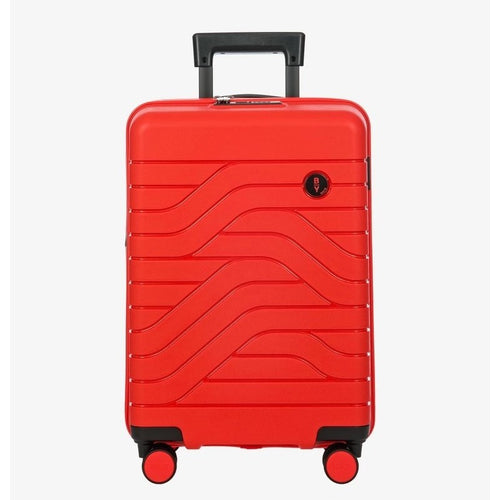 Front view of the red hard shell suitcase with black accents. The panel has a textured wave lines design, and a small black circular logo at the top right. The telescopic handle is partly pulled up.