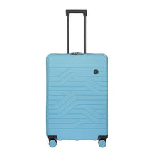 Load image into Gallery viewer, Front view of the light blue hard shell suitcase with black accents. The panel has a textured wave lines design, and a small black circular logo at the top right. The telescopic handle is pulled up.
