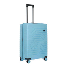 Load image into Gallery viewer, Angled front view of the light blue hard shell suitcase with black accents. The front panel has a textured wave lines design, and a small black circular logo at the top right. The telescopic handle is pulled up.

