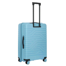 Load image into Gallery viewer, Angled back view of the light blue  hard shell suitcase with black accents. The back panel has a textured wave lines design. The telescopic handle is pulled up.
