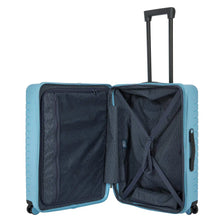 Load image into Gallery viewer, Internal view of the light blue hard shell suitcase with black accents. The fabric lining is navy blue. The front panel&#39;s side has a zipper-closing compartment. The back panel&#39;s side has a set of strips to hold contents in place. 
