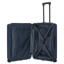 Load image into Gallery viewer, Internal view of the navy blue hard shell suitcase with black accents. The fabric lining is navy blue. The front panel&#39;s side has a zipper-closing compartment. The back panel&#39;s side has a set of strips to hold contents in place. 
