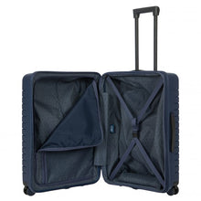 Load image into Gallery viewer, Internal view of the navy blue hard shell suitcase with black accents. The fabric lining is navy blue. The front panel&#39;s side has a zipper-closing compartment, shown partly opened. The back panel&#39;s side has a set of strips to hold contents in place. 
