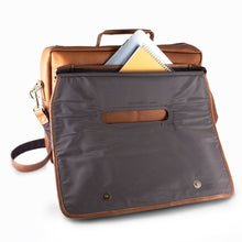 Load image into Gallery viewer,  Angled back panel view of the tan leather briefcase. The top flap is lifted backwards. A tablet and a notepad are tucked inside the opened pockets.
