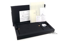 Load image into Gallery viewer, Angled view of the presentation and outer boxes arranged with the sealed ink bottle and certificates on a white background. 
