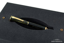 Load image into Gallery viewer, The black and green fountain pen with golden accents in the presentation box slot.
