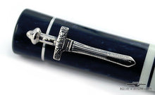 Load image into Gallery viewer, Angled close up to the sword-shaped cap clip.
