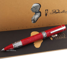 Load image into Gallery viewer, Angled front view of the red rollerball pen with the cap posted. Set with the top of the booklet and presentation box.
