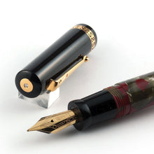 Load image into Gallery viewer, Angled close up to the fountain pen nib with the cap behind it. 
