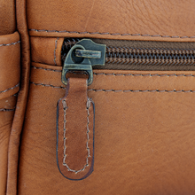 Load image into Gallery viewer, Close up to the front zipper pull on the tan leather toiletry bag.
