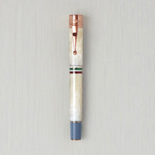 Load image into Gallery viewer, Front view of the ivory fountain pen with the cap on. It has rose gold and blue accents.
