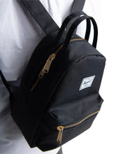 Load image into Gallery viewer, Close up to a model carrying a black Herschel nova mini backpack.
