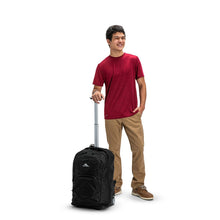 Load image into Gallery viewer, A young man holding the wheeled backpack by the telescopic handle.

