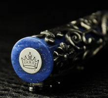 Load image into Gallery viewer, Angled close up to the medal on top of the pen cap with the Krone logo engraved.

