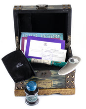 Load image into Gallery viewer, The fountain pen arranged in the presentation chest with the magnifying glass, ink bottle, certificate, and booklet.
