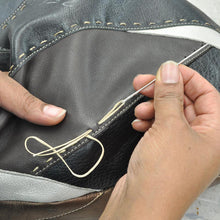 Load image into Gallery viewer, A pair of hands stitching leather.

