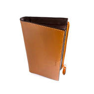 Angled front view of the toffee clutch wallet with the word LODIS embossed. 