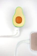 Load image into Gallery viewer, Top view of the avocado shaped power bank connected to a device.
