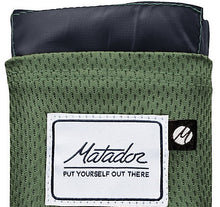 Load image into Gallery viewer, Close up to the Matador logo tag on the green blanket.
