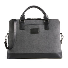 Load image into Gallery viewer, Front panel view of the briefcase with the shoulder strap leaning on the side. 
