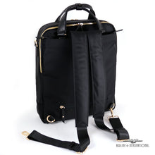 Load image into Gallery viewer, Angled back panel view of the bag with the shoulder straps outside. 
