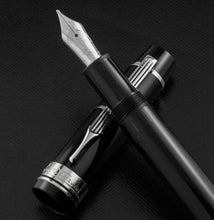 Load image into Gallery viewer, Close up to the fountain pen grip section resting on the cap. 
