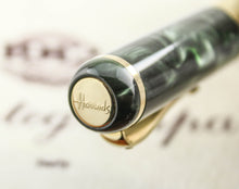 Load image into Gallery viewer, Close up to the Harrods logo on the cap's top medal

