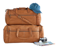 Load image into Gallery viewer, Two tan leather duffle bags arranged on a white background with a cap, magazines, a golf ball and a film camera.
