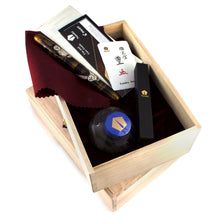Load image into Gallery viewer, The fountain pen arranged in the wooden presentation box with the ink bottle, eye dropper, certificates, and red cloth.
