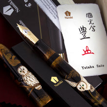 Load image into Gallery viewer, Close up to the fountain pen arranged in the presentation box with the cap, artist card, and certificates.
