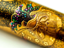 Load image into Gallery viewer, Close up to the gold and abalone shell decorations on the pen barrel. 
