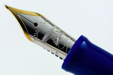 Load image into Gallery viewer, Close up to the two-toned fountain pen nib with engraved text and decorations. 
