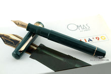 Load image into Gallery viewer, Angled view of the fountain pen resting on the cap. Both are placed on top of the outer box.
