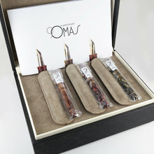 Load image into Gallery viewer, Three fountain pens arranged with the pen sleeves on the presentation box with the included booklet.
