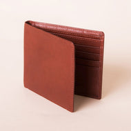Angled front view of the tan leather wallet. 