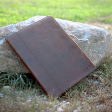 Load image into Gallery viewer, The brown letter pad leaning on a stone in a grassy area

