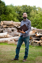 Load image into Gallery viewer, A man holding the letter pad on a blurry outside background. 

