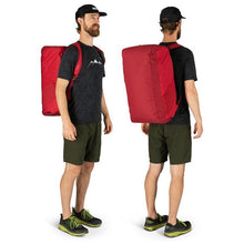Load image into Gallery viewer, A young man carrying the Cosmic red duffle like a backpack.
