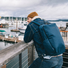 Load image into Gallery viewer, A man overseeing a pier while carrying the blue backpack.
