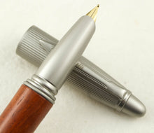Load image into Gallery viewer, Close up to the grip section leaning on the cap.
